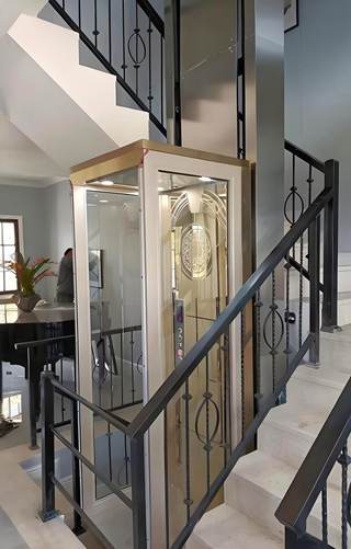 a golden frame home elevator lift installed beside a staircase